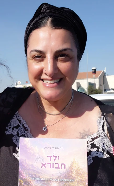 הלן תהילה רחמים מחזיקה את ספרה ילד הבורא